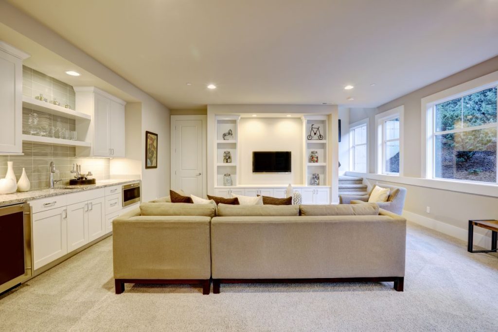 Bright modern finished basement with wet bar and lounge area