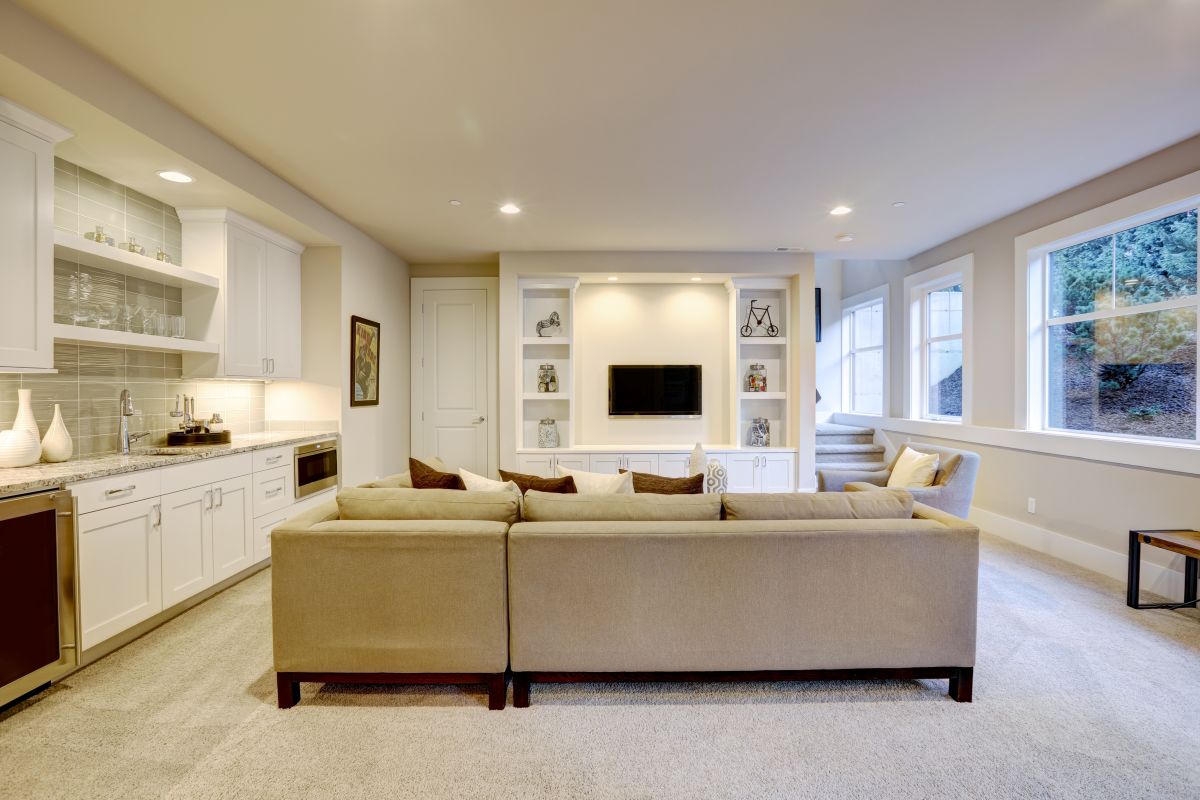 Bright modern finished basement with wet bar and lounge area