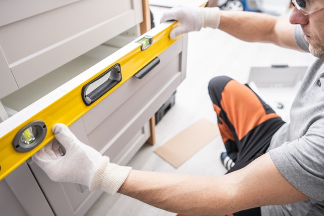 kitchen remodeling contractor fitting kitchen cabinets during install